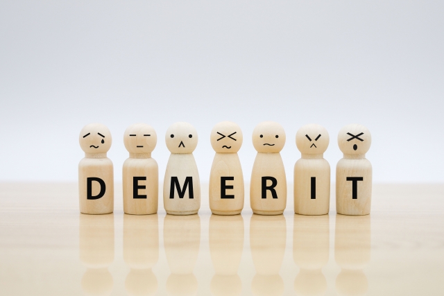 DEMERITと書かれた木の人形