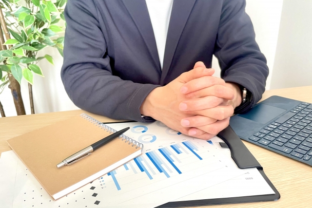 棒線グラフと手を組む人