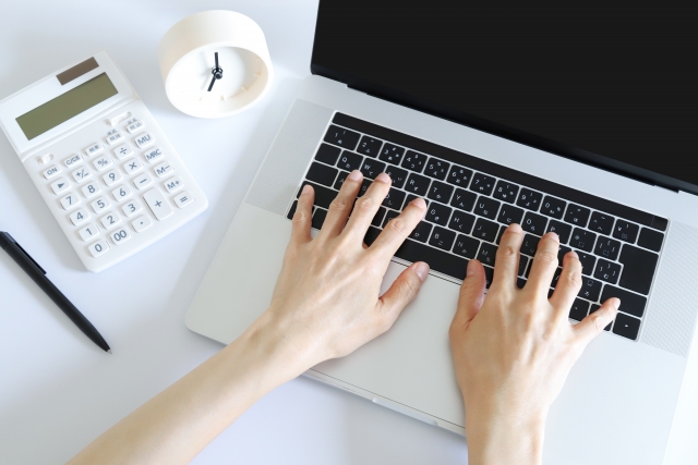 パソコンとキーボードを打つ手