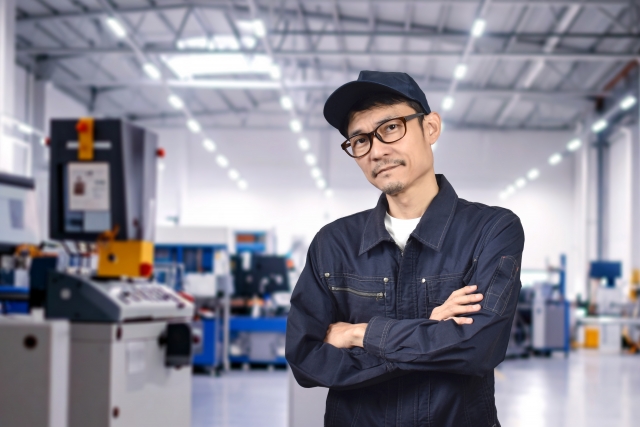 工場で腕を組む男性