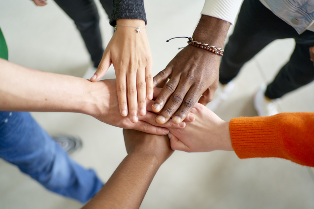 手を重ねる人々