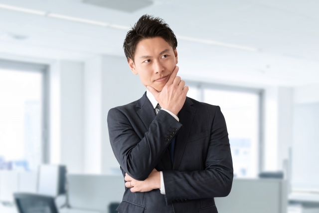 腕組をして悩む男性