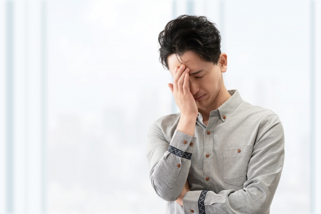 頭を悩ませる男性