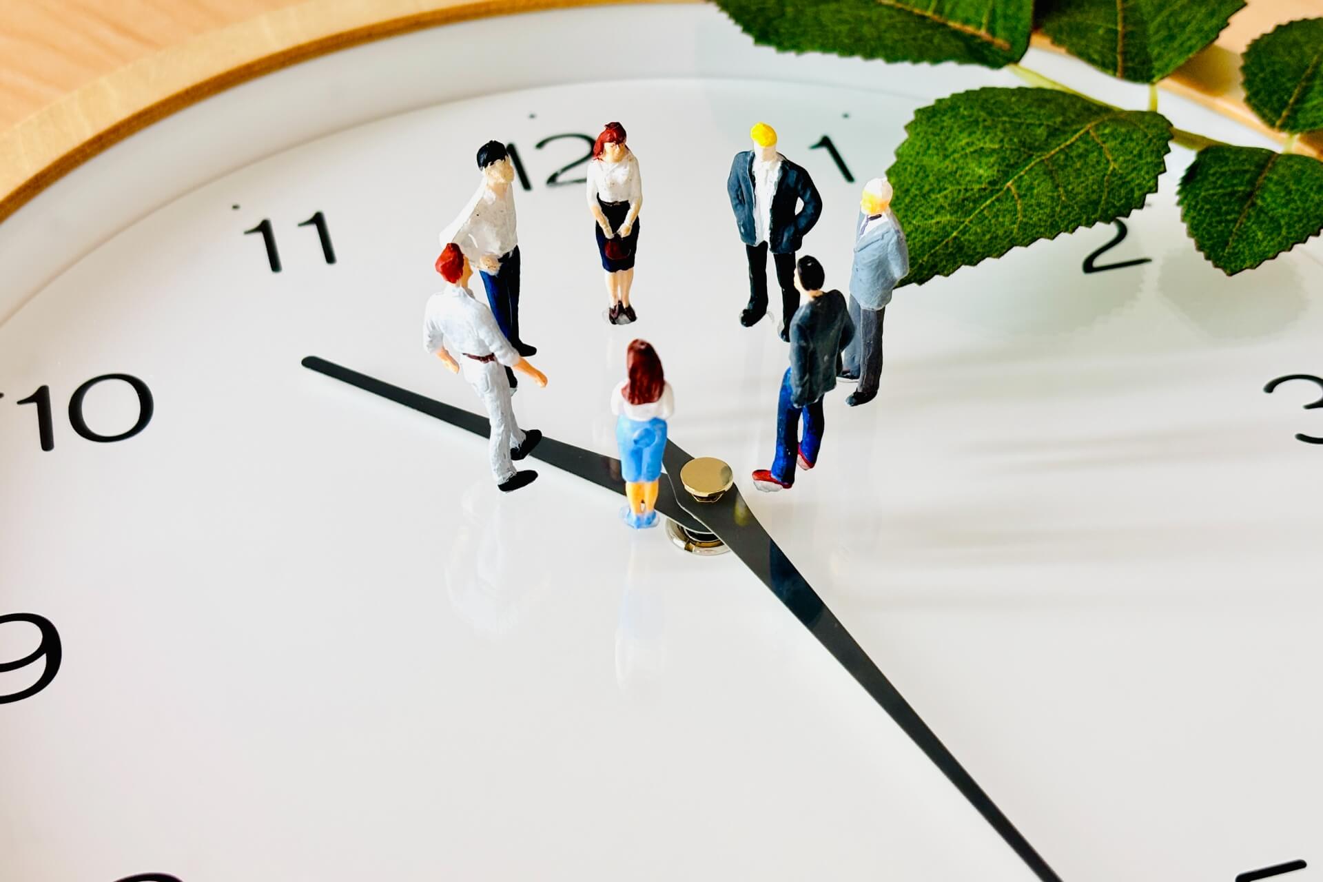 裁量労働制の理解・確認のイメージ：時計の上に集まるビジネスパーソンのミニチュア