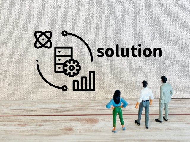 ソリューションと書かれた壁を見上げる男女