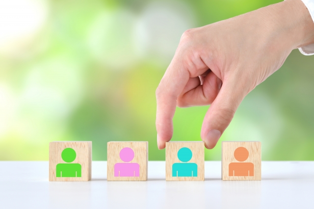 人が書かれた木の箱を掴む人の手